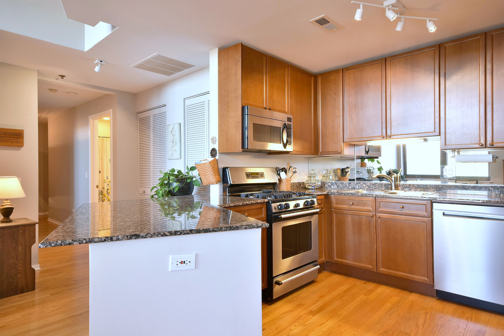 1201 West Adams Street, Unit 411 Chicago, IL 60607 - Photo 8 of 40 a kitchen with stainless steel appliances granite countertop a stove a sink and a microwave