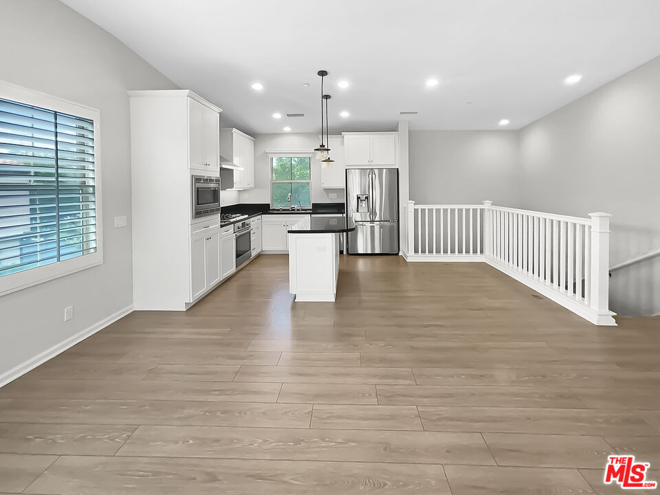 50 Evening Sun Irvine, CA 92620 - Photo 11 of 15 a view of kitchen dining table chairs microwave and cabinets