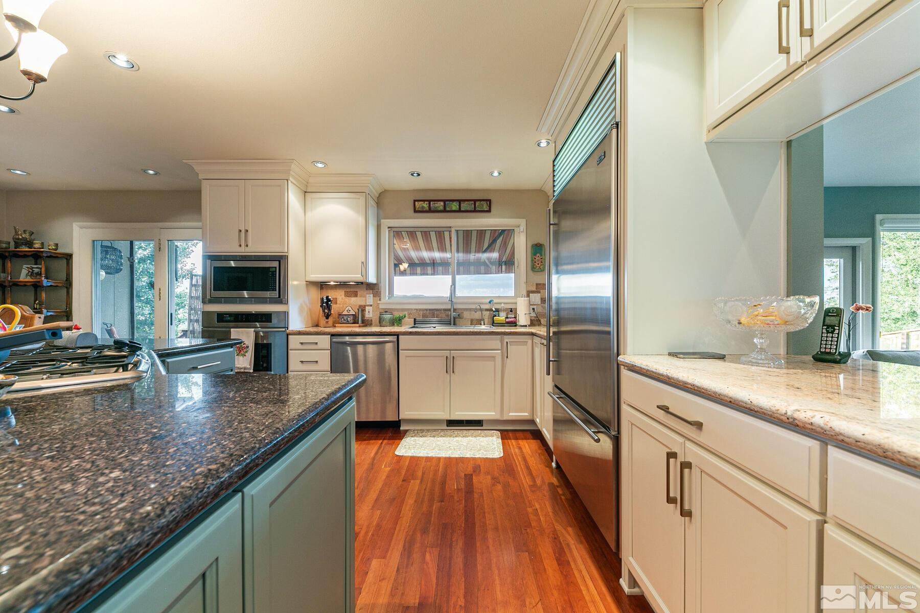 2025 Heatheridge Lane Reno, NV 89509 - Photo 25 of 40 a kitchen with stainless steel appliances granite countertop lots of counter top space and wooden floor