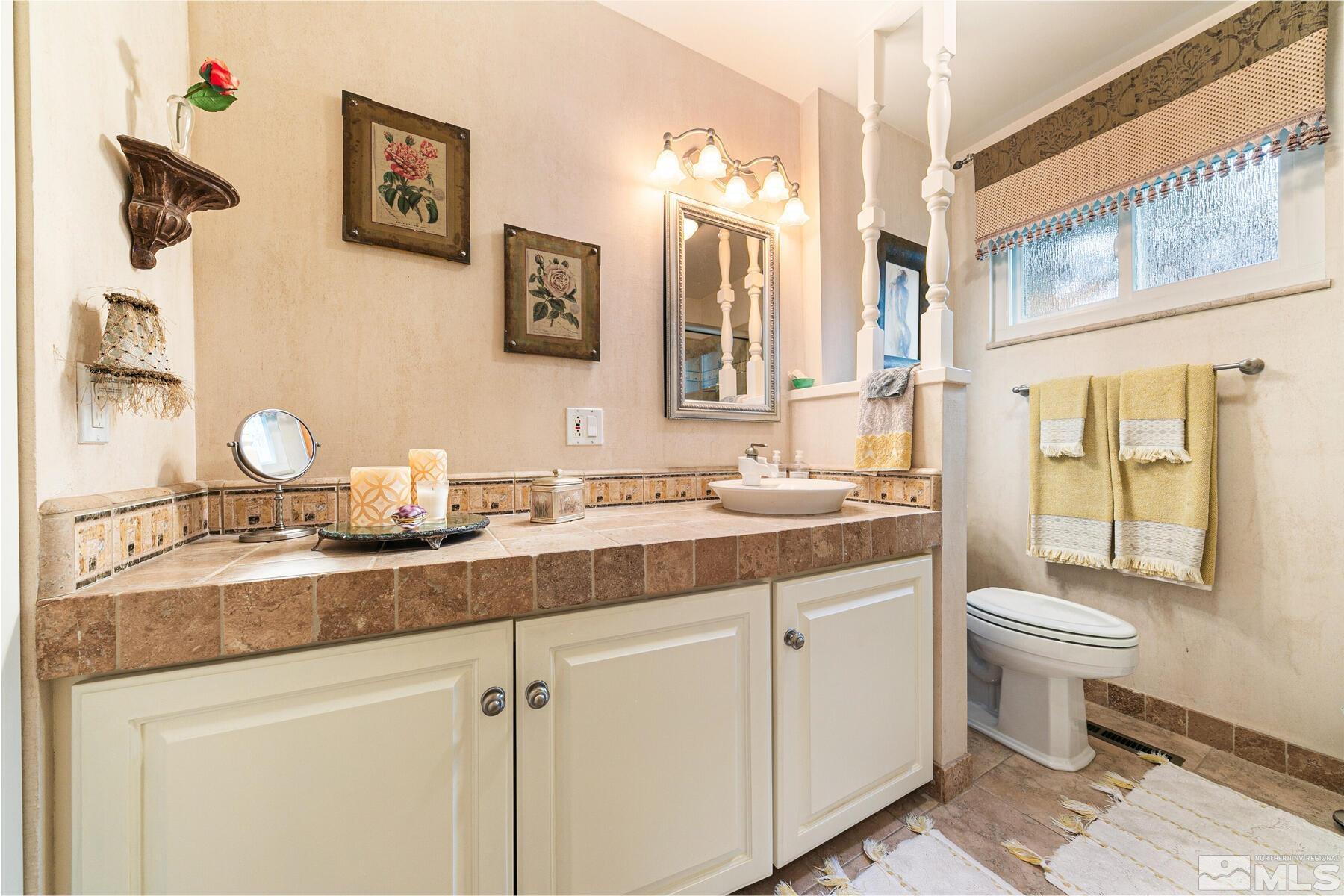 2025 Heatheridge Lane Reno, NV 89509 - Photo 39 of 40 a bathroom with a double vanity sink toilet and mirror