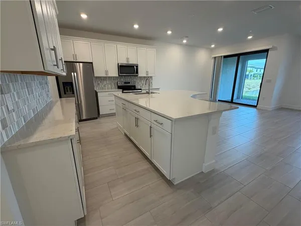 a kitchen with stainless steel appliances a refrigerator and a stove top oven