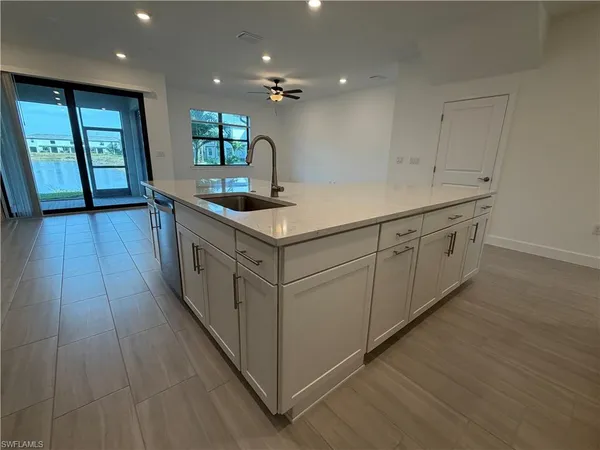 a kitchen with white cabinets stove and sink