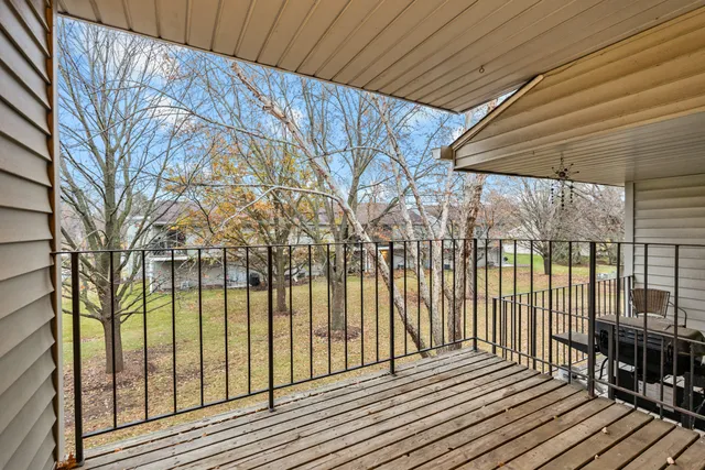 a view of a balcony with wooden floor and iron fence
