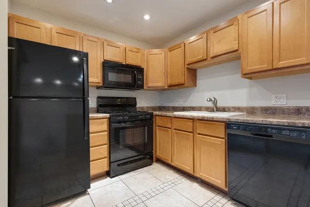 a kitchen with stainless steel appliances granite countertop a refrigerator and a stove top oven