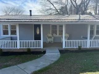 a view of a house with a deck and a yard