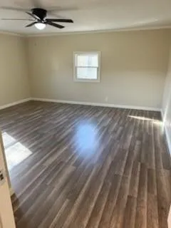 en empty room with wooden floor and windows