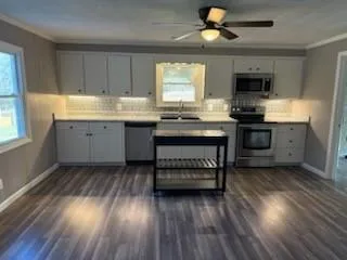 a kitchen with a sink cabinets and wooden floor