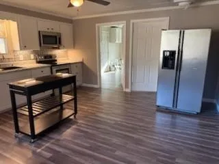 a kitchen with stainless steel appliances wooden floor and a refrigerator