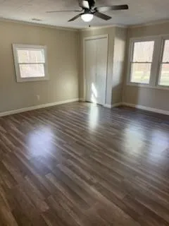 an empty room with wooden floor and windows
