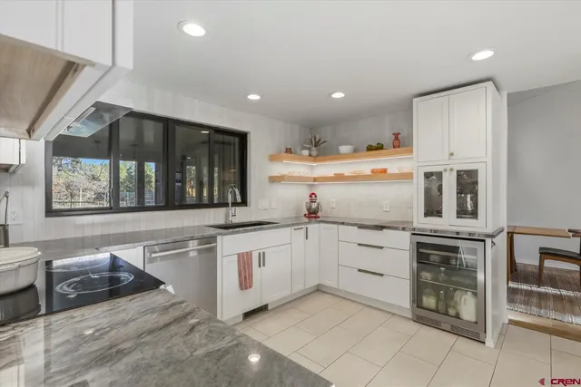 a kitchen with granite countertop white cabinets and white appliances