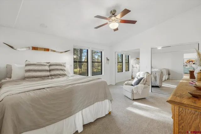 a spacious bedroom with a bed a couch and a chandelier