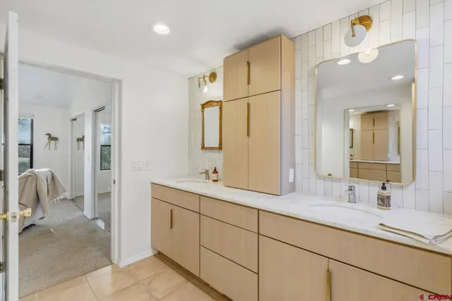 a bathroom with a double vanity sink mirror and shower
