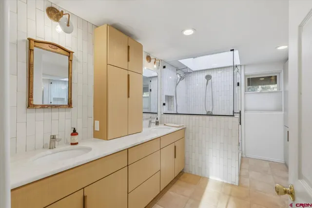 a spacious bathroom with a shower sink and mirror