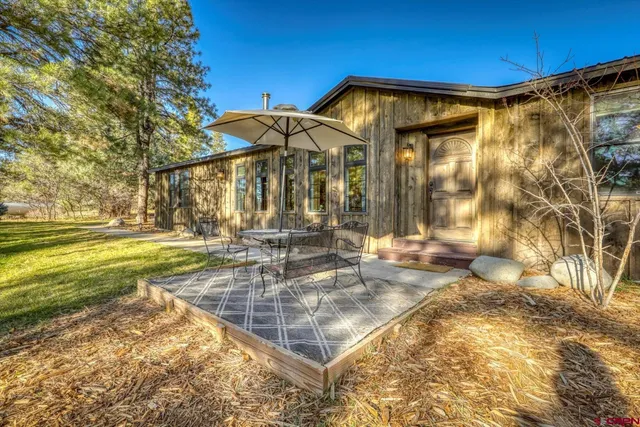 a view of a house with backyard and sitting area