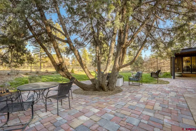 a view of a chairs and table in backyard of the house