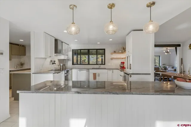 a kitchen with stainless steel appliances granite countertop a sink a stove and a refrigerator