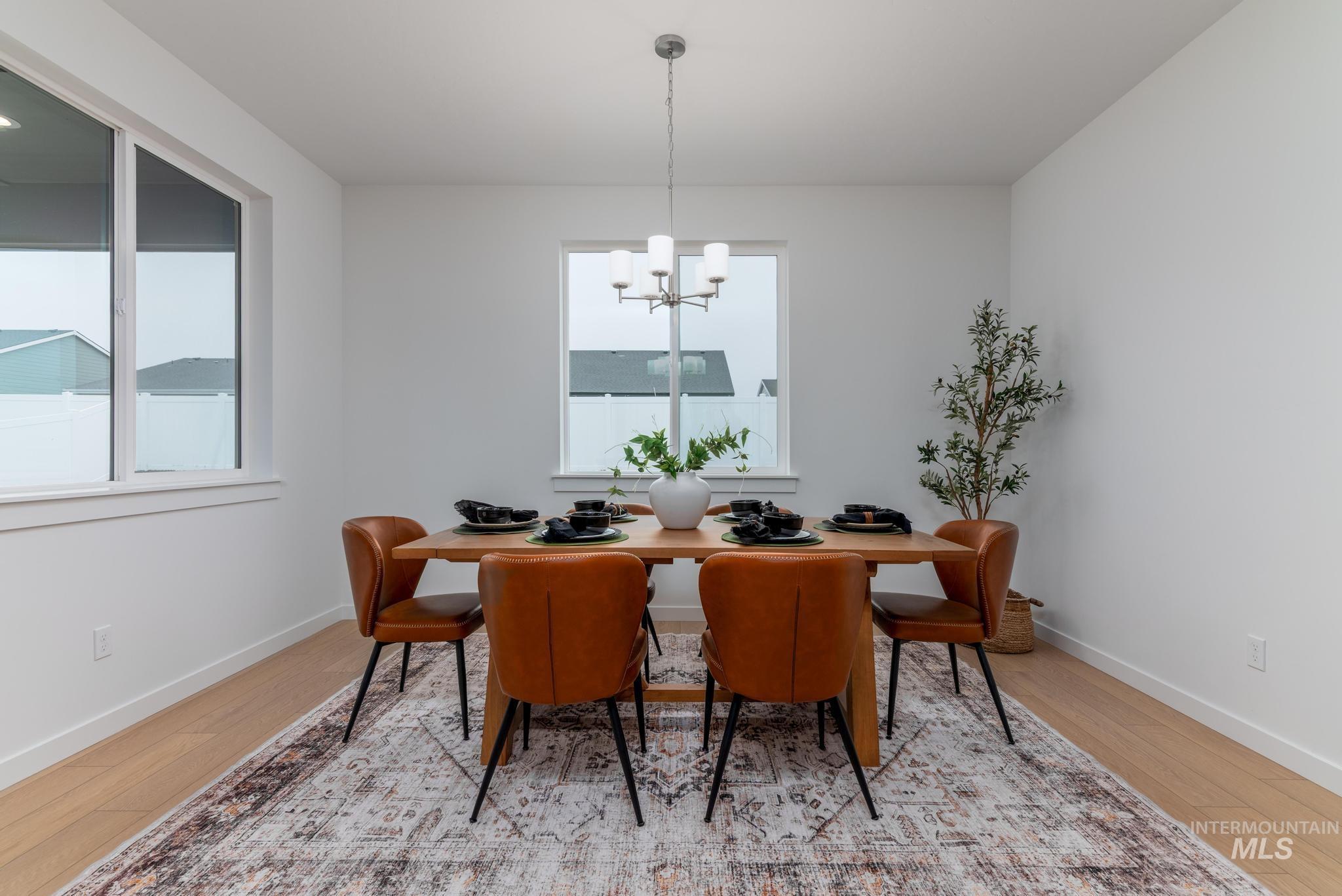 6285 West Snow Currant Street Meridian, ID 83646 - Photo 6 of 10 Dining room with light wood-style flooring and a chandelier