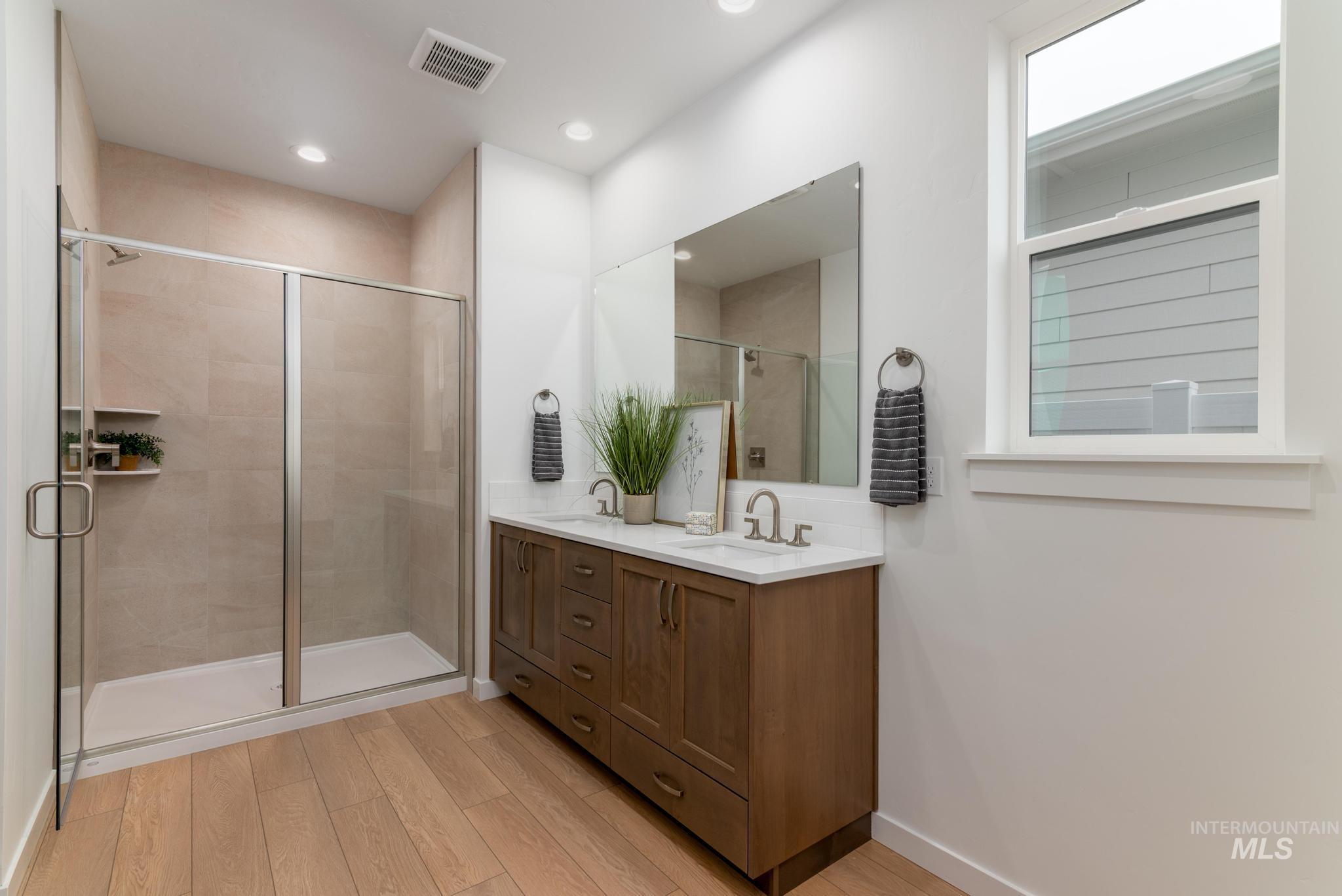 6285 West Snow Currant Street Meridian, ID 83646 - Photo 8 of 10 Full bathroom featuring a shower stall, double vanity, light wood-style floors, and recessed lighting