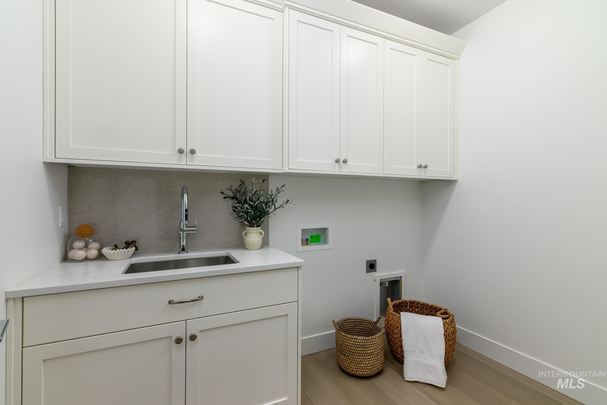 6285 West Snow Currant Street Meridian, ID 83646 - Photo 9 of 10 Laundry area with hookup for a washing machine, light wood-style floors, electric dryer hookup, and cabinet space