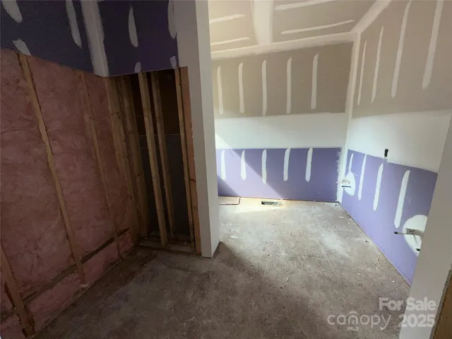 a view of an empty room with wooden floor and cabinet