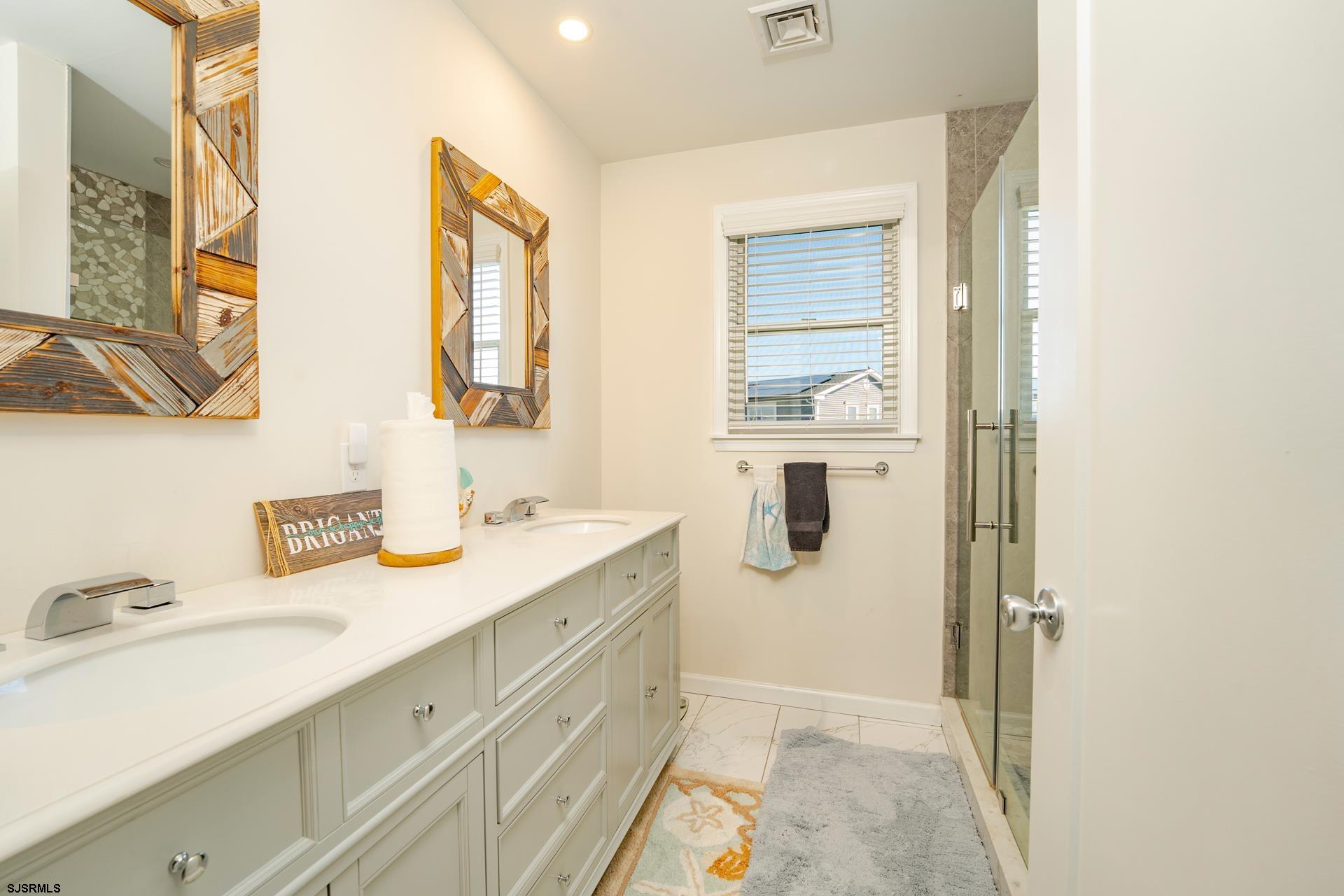 703 Bobby Jones Road Brigantine, NJ 08203 - Photo 12 of 34 a bathroom with a granite countertop sink a mirror and a shower