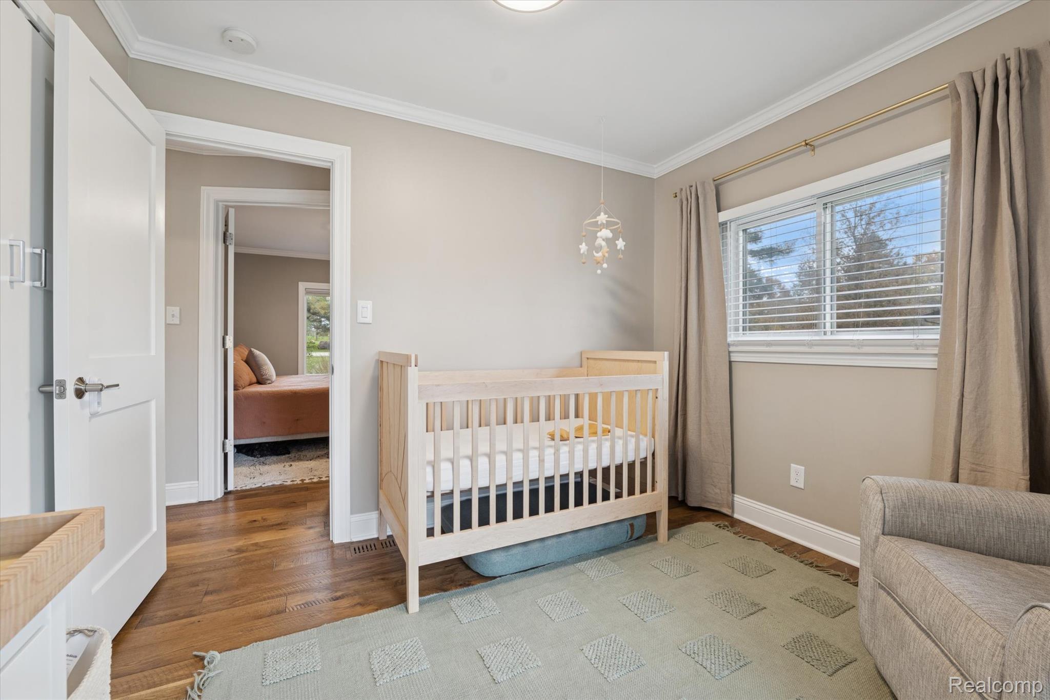 5100 Oakhill Road Clarkston, MI 48348 - Photo 28 of 54 Bedroom featuring a crib, crown molding, and light wood-style flooring