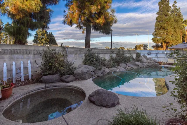 a swimming pool with outdoor seating and plants