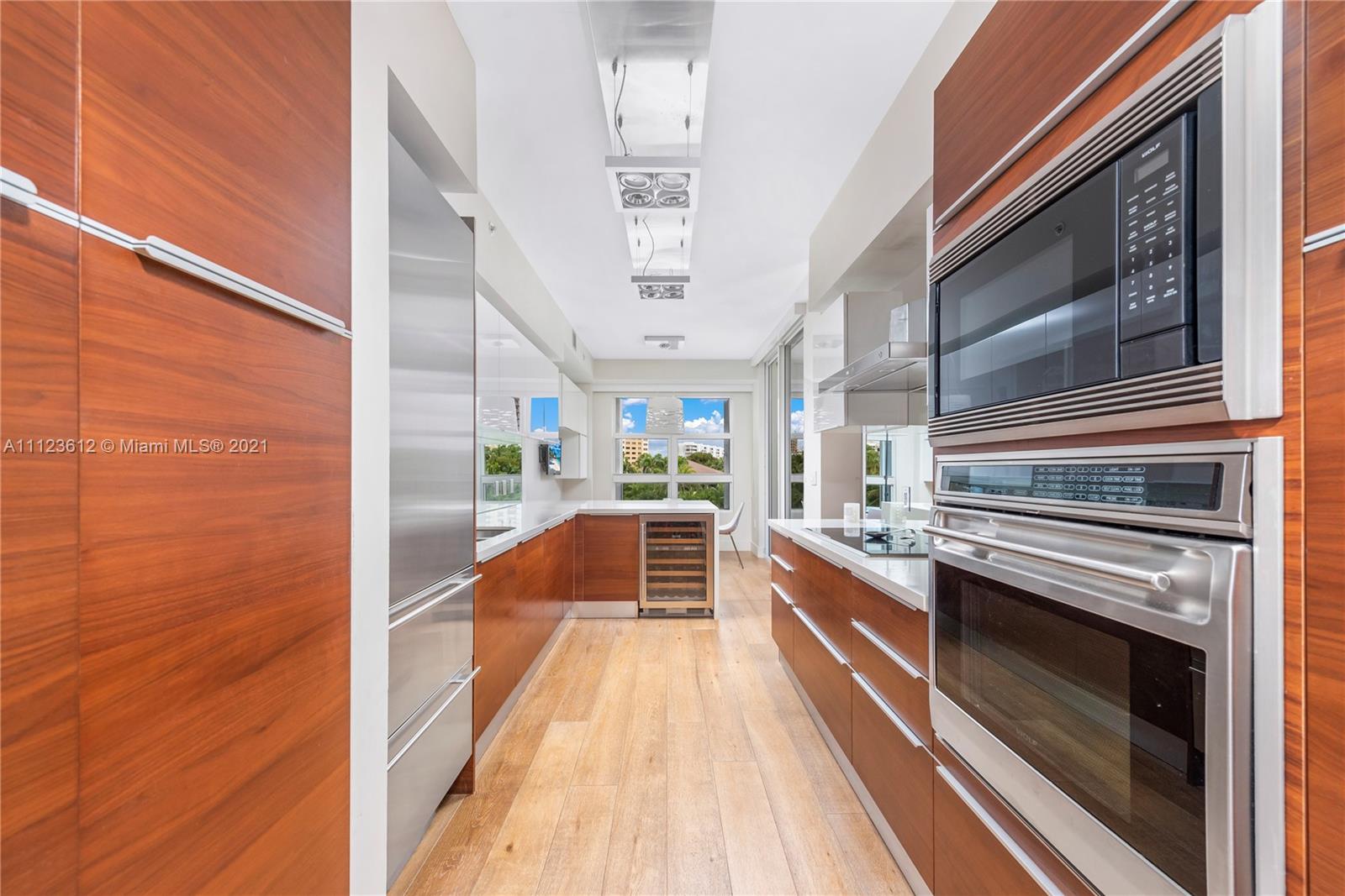739 Crandon Boulevard, Unit PH1 Key Biscayne, FL 33149 - Photo 13 of 33 a large kitchen with kitchen island wooden floor and stainless steel appliances