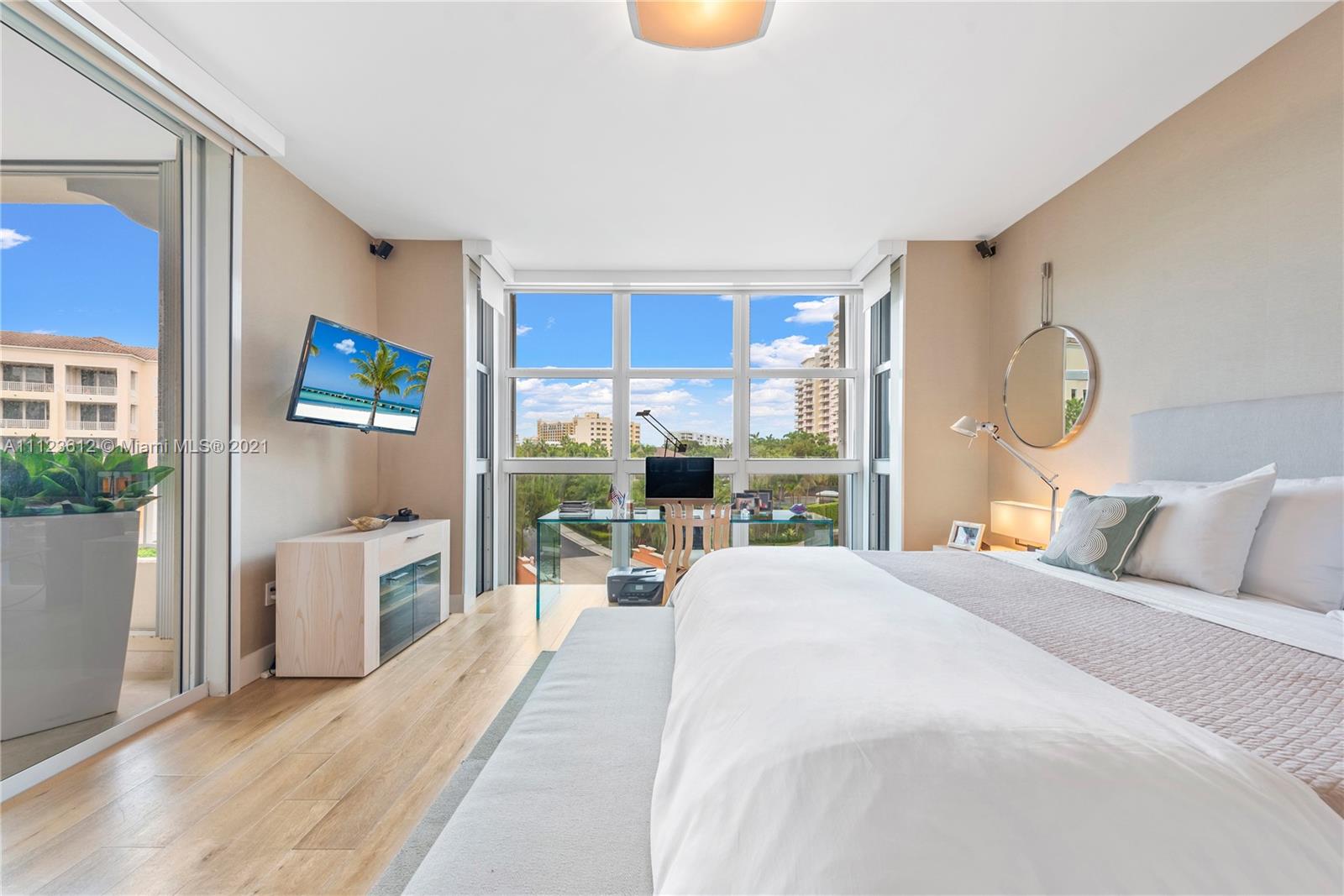 739 Crandon Boulevard, Unit PH1 Key Biscayne, FL 33149 - Photo 17 of 33 a bedroom with a bed a table and chair