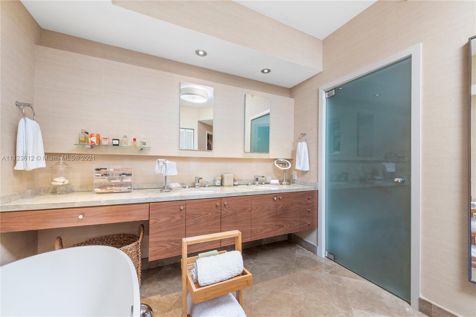 739 Crandon Boulevard, Unit PH1 Key Biscayne, FL 33149 - Photo 20 of 33 a bathroom with a sink a toilet and a mirror