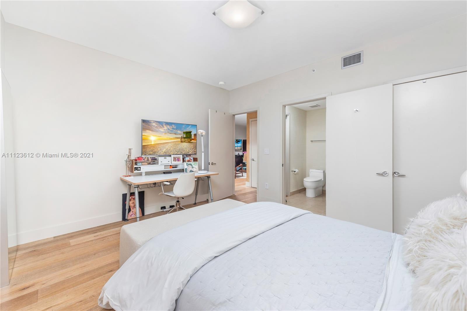 739 Crandon Boulevard, Unit PH1 Key Biscayne, FL 33149 - Photo 22 of 33 a bedroom with a bed and a table in it