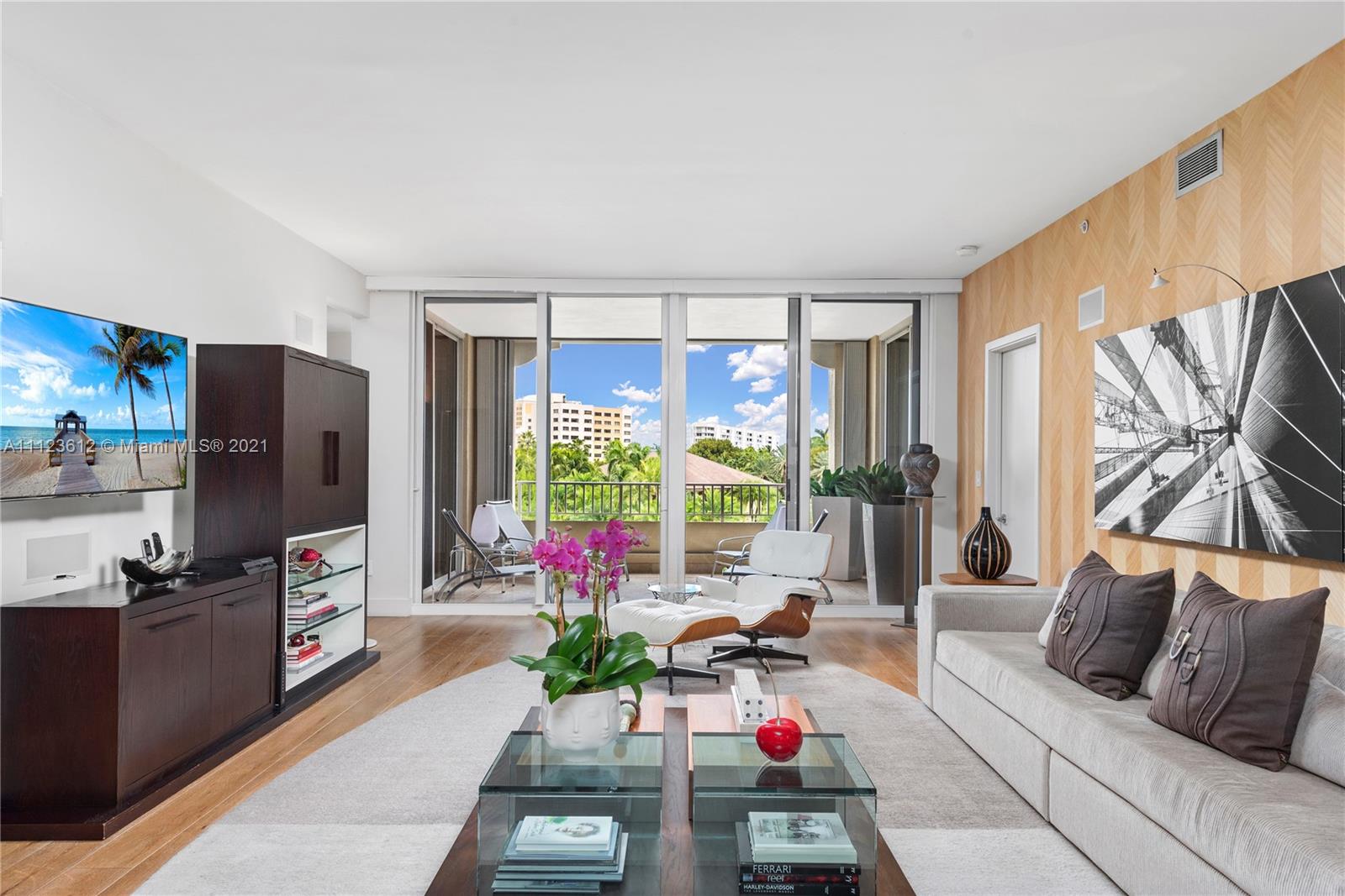 739 Crandon Boulevard, Unit PH1 Key Biscayne, FL 33149 - Photo 4 of 33 a bedroom with furniture a flat screen tv and a large window