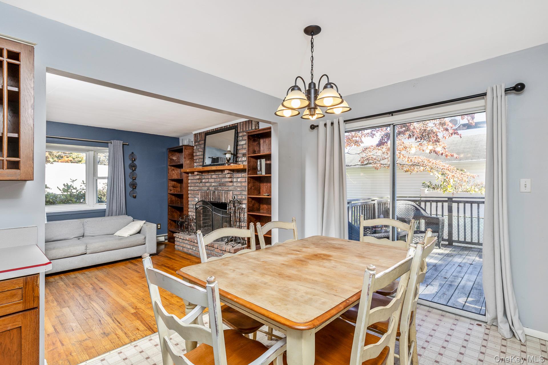 12 Applegate Drive Mastic, NY 11950 - Photo 14 of 29 Dining space featuring a fireplace and a chandelier