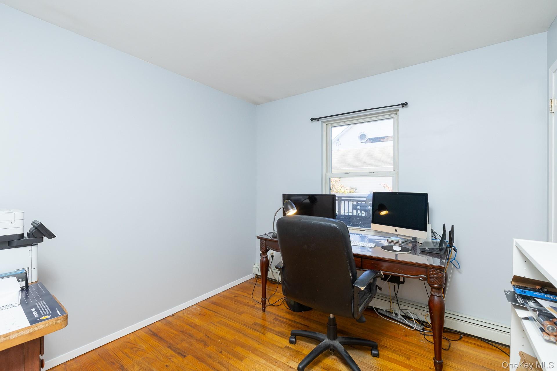 12 Applegate Drive Mastic, NY 11950 - Photo 16 of 29 Office area featuring light wood-style flooring and a baseboard heating unit