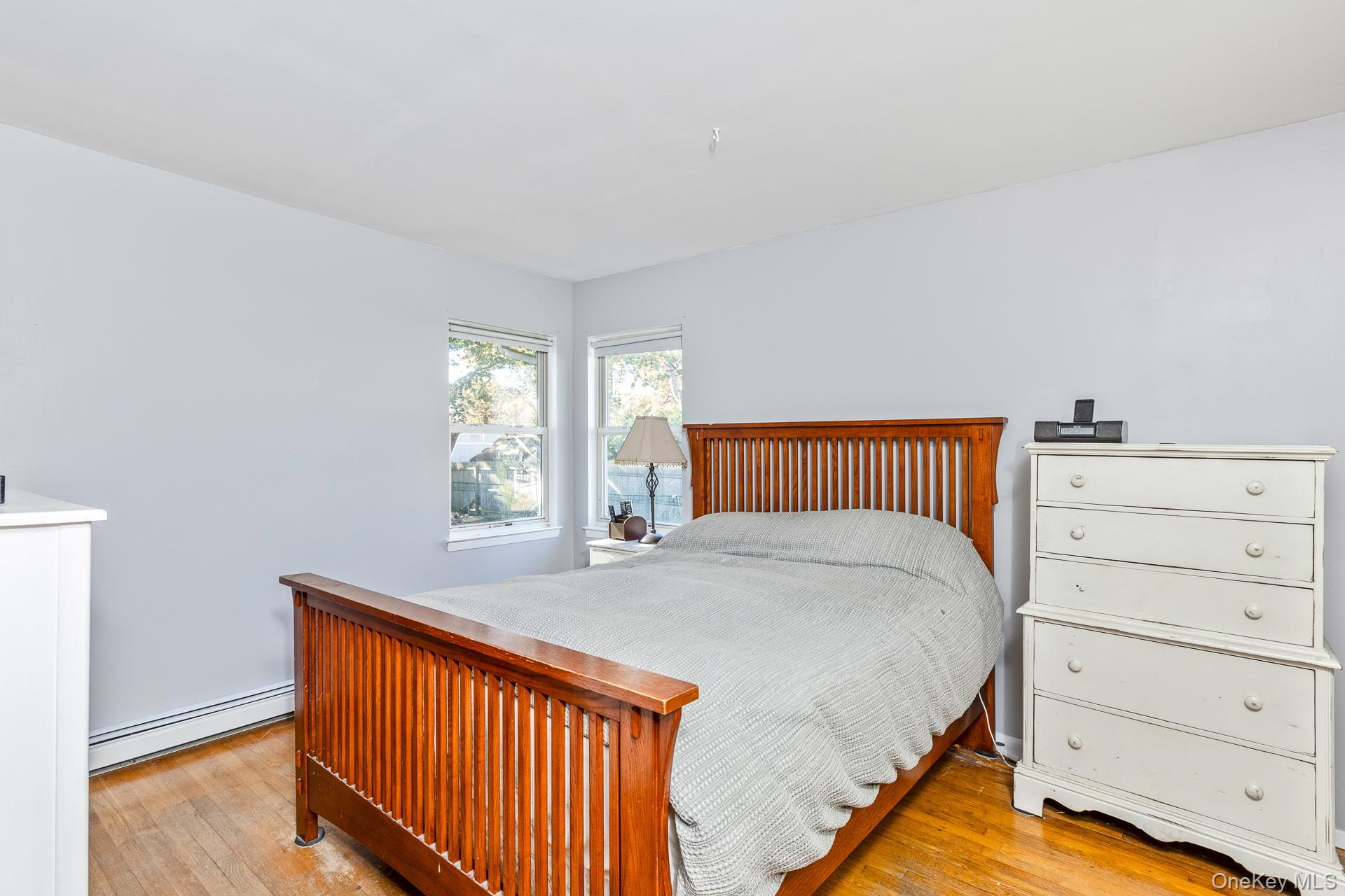 12 Applegate Drive Mastic, NY 11950 - Photo 17 of 29 Bedroom with light wood-style flooring and a baseboard heating unit