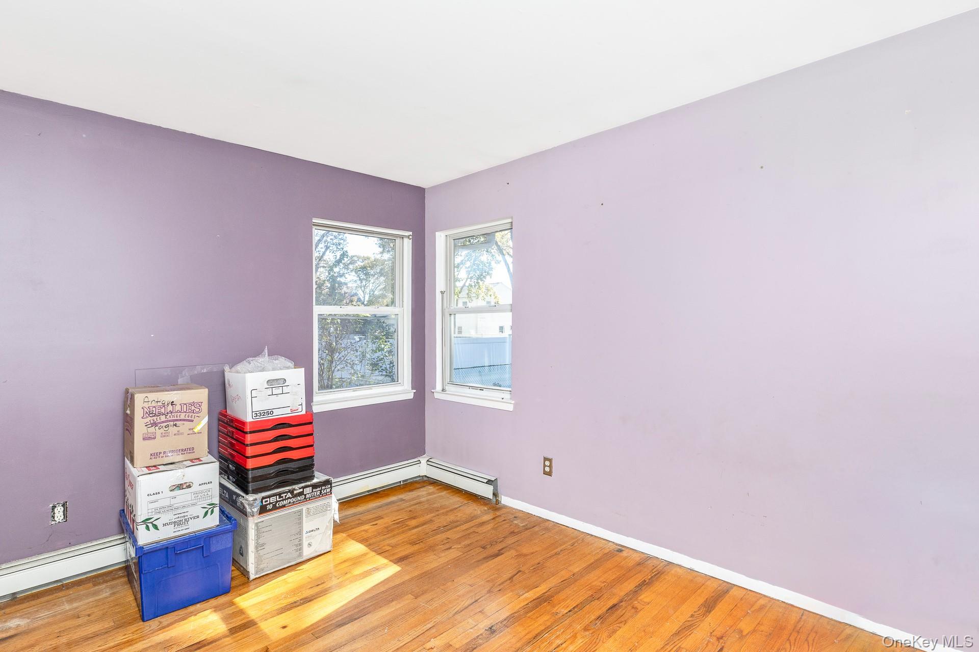 12 Applegate Drive Mastic, NY 11950 - Photo 18 of 29 Bedroom with light wood finished floors and a baseboard radiator