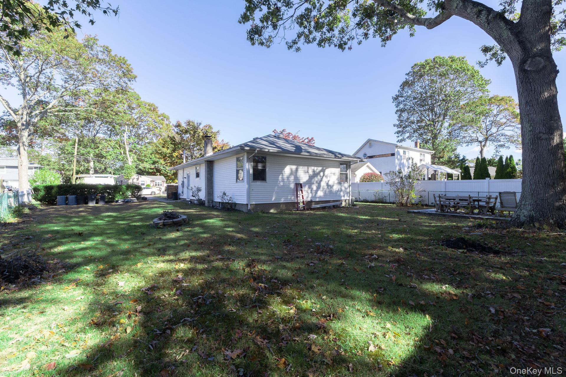 12 Applegate Drive Mastic, NY 11950 - Photo 27 of 29 Fenced backyard featuring a fire pit