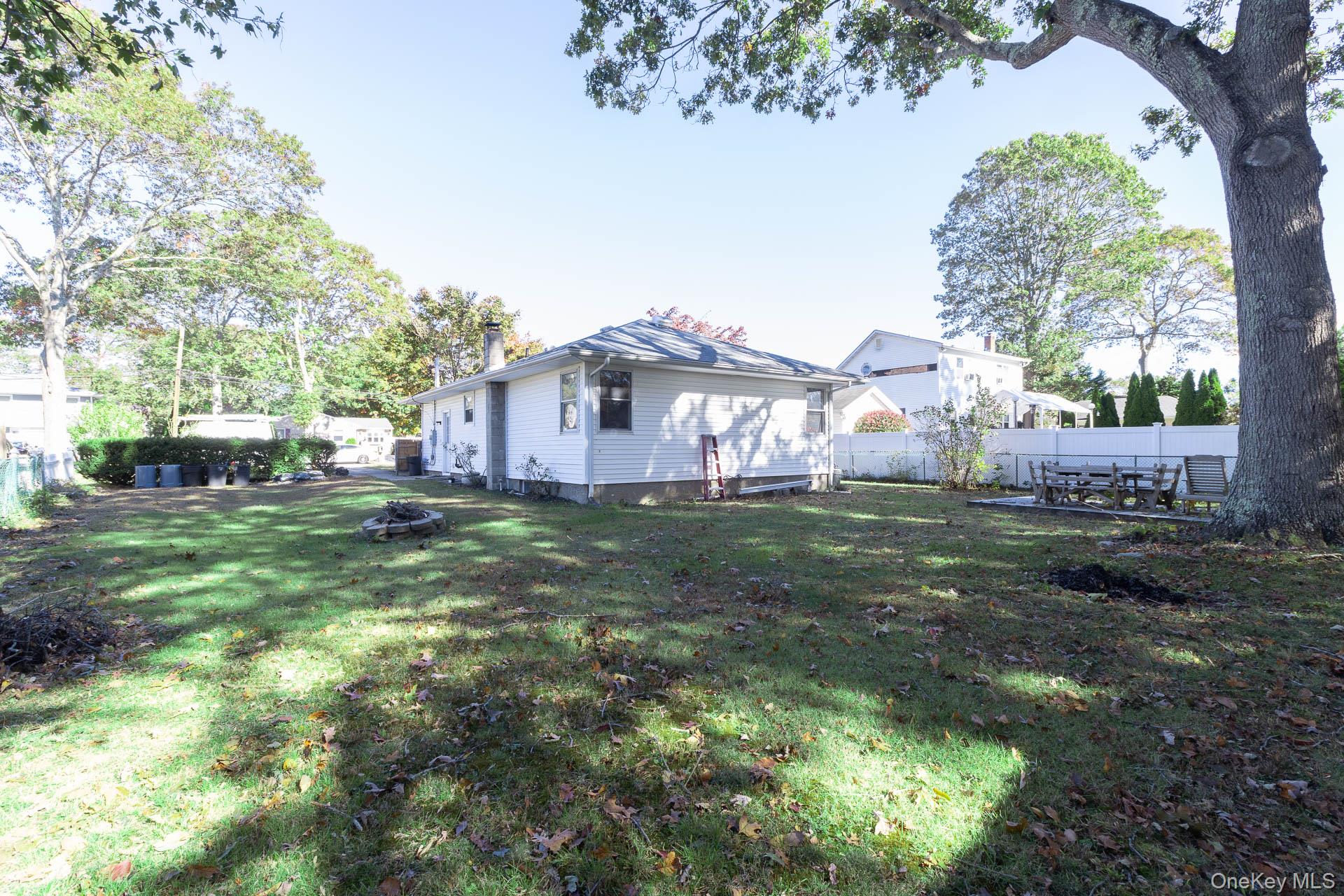 12 Applegate Drive Mastic, NY 11950 - Photo 28 of 29 Fenced backyard featuring an outdoor fire pit