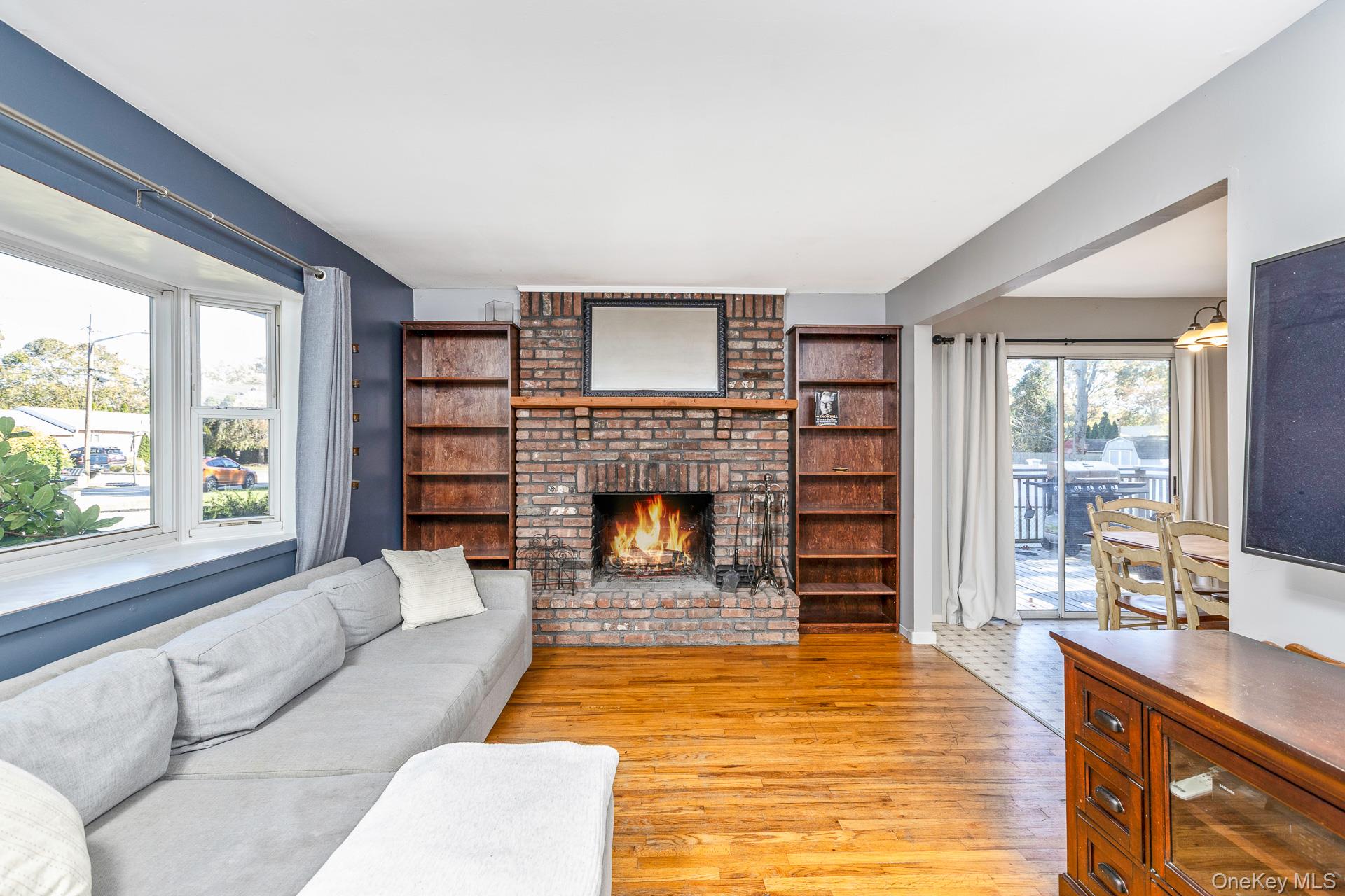 12 Applegate Drive Mastic, NY 11950 - Photo 8 of 29 Living room featuring light wood finished floors and a brick fireplace