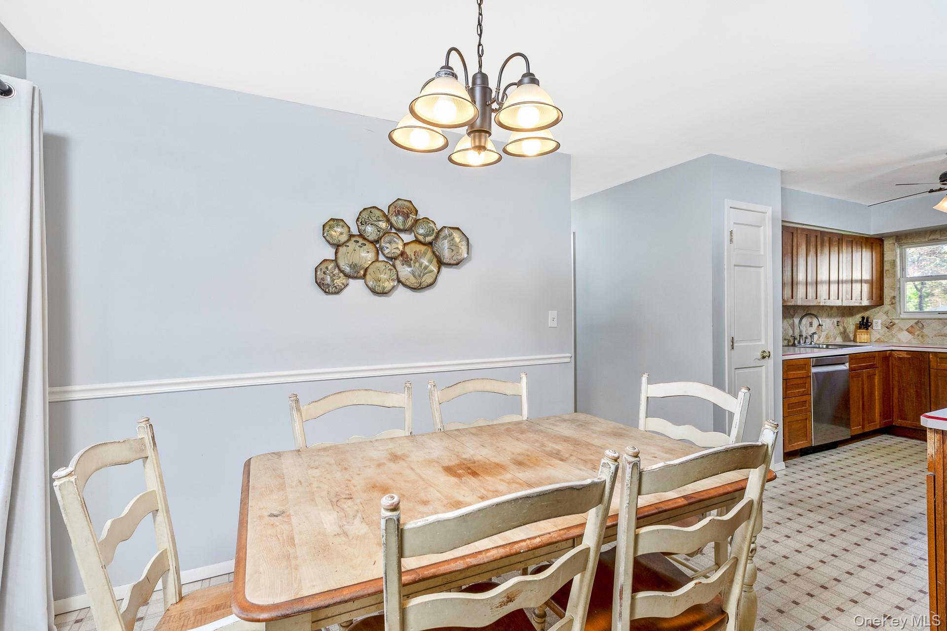 12 Applegate Drive Mastic, NY 11950 - Photo 10 of 29 Dining space featuring a chandelier, ceiling fan, and light flooring