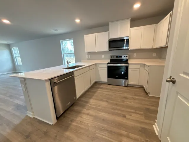 a kitchen with granite countertop a stove top oven sink and cabinets