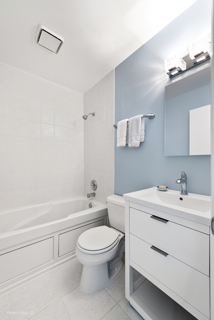 4938 South Drexel Boulevard, Unit 310 Chicago, IL 60615 - Photo 7 of 20 a bathroom with a white toilet sitting next to a bathroom sink and a shower