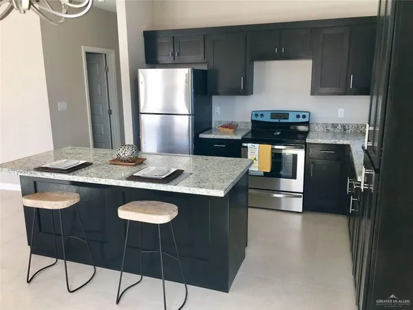a kitchen with a kitchen island a stove a table and chairs in it