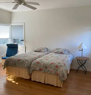 a bedroom with two beds and painting on the wall