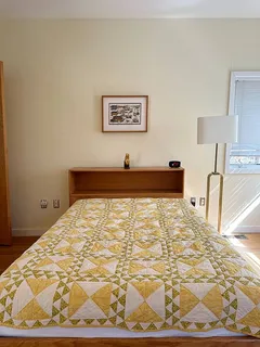 a bed sitting in a bedroom next to a lamp