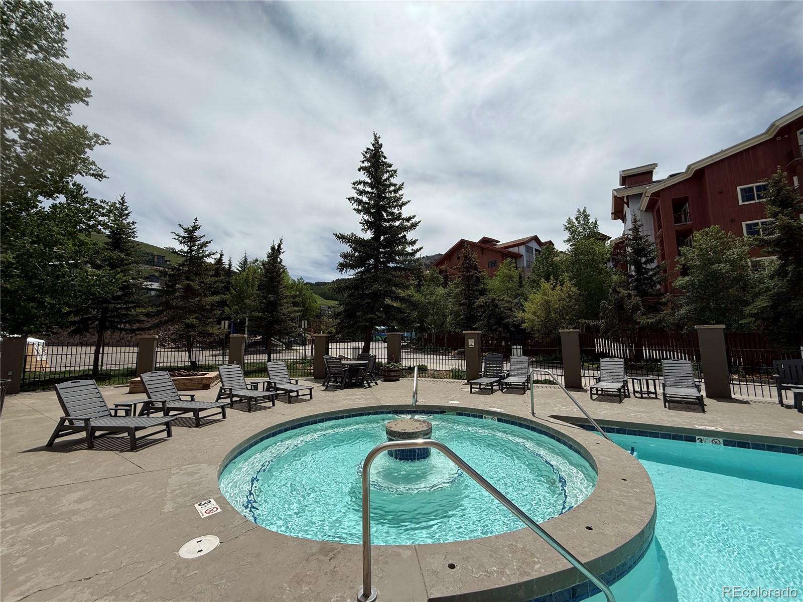 6 Emmons Road, Unit 379/381 Crested Butte, CO 81225 - Photo 28 of 34 a swimming pool with outdoor seating and yard