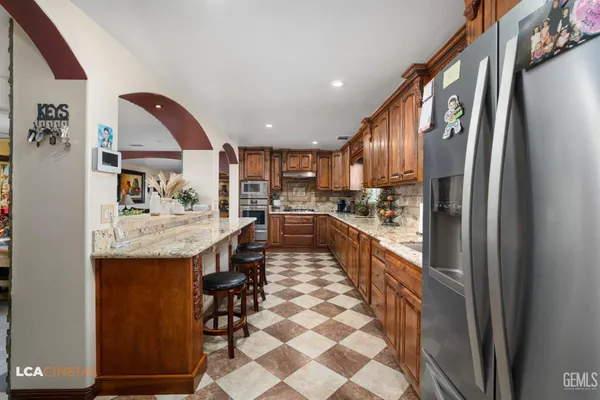 a kitchen with stainless steel appliances granite countertop a stove a sink and a microwave