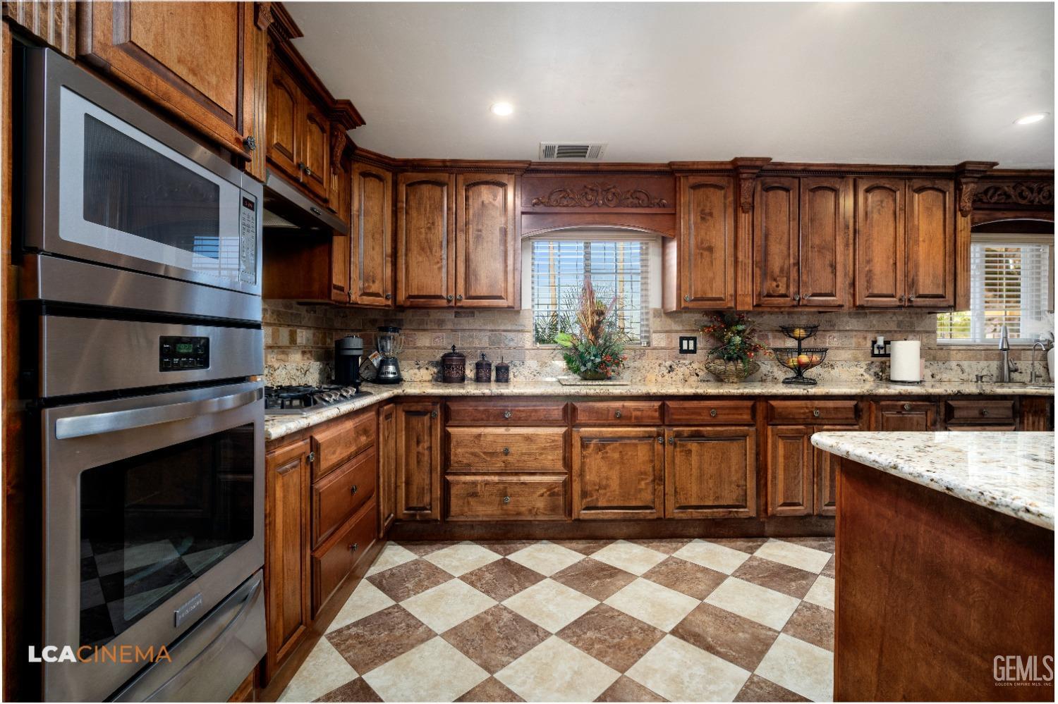 Undisclosed Address Pixley, CA 93256 - Photo 15 of 45 a kitchen with stainless steel appliances granite countertop a stove a sink and a microwave