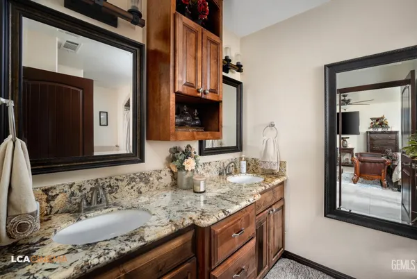 a view of a hallway with wooden floor and a bathroom
