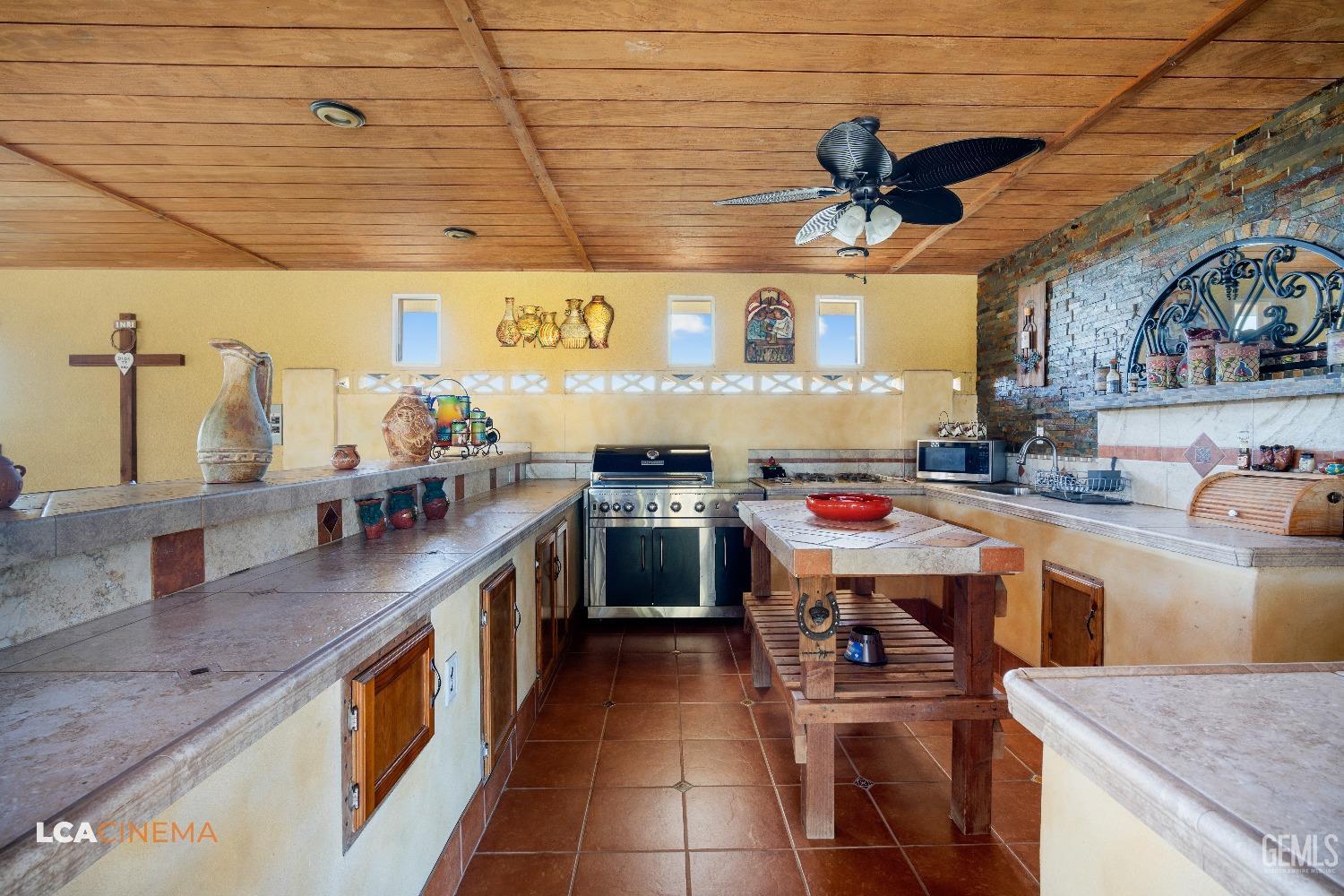 Undisclosed Address Pixley, CA 93256 - Photo 38 of 45 a kitchen with kitchen island a stove and a sink